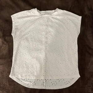 T-shirt från only - En jättefin t-shirt från märket only! Den har håliga mönster över hela tröjan och är kortare framifrån. Storlek xs men är rätt stor och passa S med! Använd fåtal gånger! Orginalpris 229kr