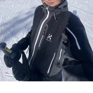 Skid/ skaljacka haglöfs - Grå och svart jacka från haglöfs som är köpt på plick men säljer då den inte passade mig. Använd endast ett få tal gånger av tidigare ägare. Perfekt till fjällen med snölås, ficka för liftkort, recco osv! (Lånade bilder)