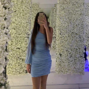 Jätte fin ljusblå oneshoulder klänning  - Säljer en superfin ljusblå oneshoulder klänning i syntetmaterial. Den har en tight passform och är perfekt för fest. Klänningen har en snygg rynkad design som ger en extra touch. Perfekt för att sticka ut på festen! 💙