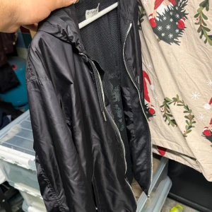 Svart vindjacka från Givenchy - Säljer en snygg svart vindjacka från Givenchy. Jackan har en dragkedja framtill och är perfekt för höst och vår. Den har en normal passform och är långärmad. Perfekt för att hålla stilen när det blåser ute!