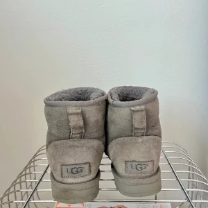 Gråa UGGs - Säljer ett par äkta grå UGGs i bra skick. Några få defekter då de är använda, lite missfärgat på ena  hälen (se bild) men de har mycket kvar att ge, ootsens utsida är i mocka och insida i ull.