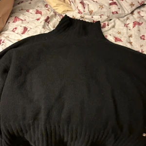 Svart polotröja från Pernilla Wahlgren - Säljer en stilren svart polotröja från Pernilla Wahlgren. Tröjan har en hög krage och är perfekt för kyligare dagar. Den är mjuk och bekväm, vilket gör den till ett utmärkt val för både vardag och speciella tillfällen.