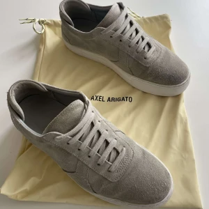Axel Arigato skor  - Säljer dessa Axel Arigato skor i väldigt bra skick, sparsamt använda och som man kan se i väldigt bra skick. Sulan är lite smutsig men går självklart att rengöra! (Påse ingår ej) skriv vid mer frågor och info🙌😀