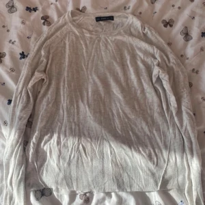 Vit stickad tröja från Zara - Säljer en vit stickad tröja från Zara i storlek S. Tröjan är supermjuk och perfekt för kyliga dagar. Den har långa ärmar och en klassisk passform som funkar till allt. Perfekt för både vardag och mysiga hemmakvällar. 🧶