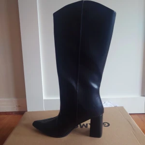 Vida svarta stövlar (oanvända) - Svarta stövlar i fejkskinn, vid modell. Helt oanvända med prislappar kvar. Originalpris 689.