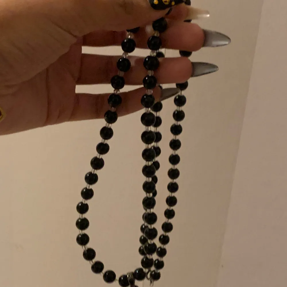 svart pärlhalsband med en björn.  björnen har stenar i form av ett hjärta, en sten saknas. björnen kan röra på armar och ben fritt.  kontakta mig för fler bilder eller frågor!! 🖤. Accessoarer.