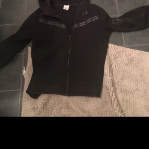 Nike tech - Säljer min Nike tech då den inte används och är förliten. Den är lite solblekt på luvan! Pris kan diskuteras!