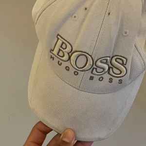 Hugo Boss keps  - Hugo boss keps, vit färg, den är nyligen köpt och färgen är bra och kvaliteten,  Båda för tjejer och killar 