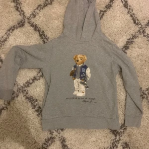  Ralph Lauren hoodie - Jag säljer min Polo Ralph lauren hoodie i färgen grå i storlek 14-16 år. Hoodien är liten i storleken. 