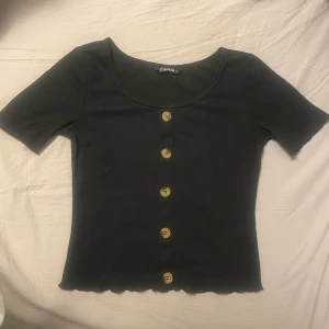 Svart topp med knappar - Säljer en  svart topp från SHEIN som är sparsamt användt. 