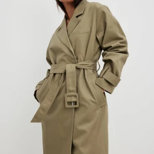 NA-KD grön trenchcoat  - Grön/khaki trenchcoat i 100% bomull från NAKD i nyskick  Storlek 38   Nypris 1099kr