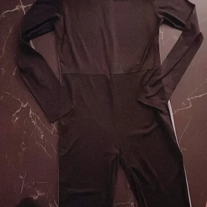 Svart långärmad klänning - Säljer en elegant svart långärmad klänning i ett mjukt och stretchigt material. Perfekt för höst och vinter, den har en stilren design som passar både till vardags och fest. Klänningen är i nyskick och har en figurnära passform.