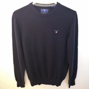 Lammullströja från Gant - Mörkblå lammullströja från GANT. Storlek Small. Fint skick. Nypris 1400 kr. Köparen står för fraktkostnaden. 