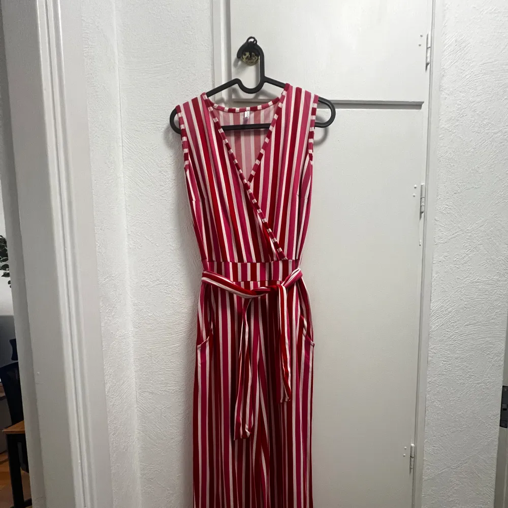 Färgglad jumpsuit Använd 2 ggr Stretchig och väldigt bekväm  Passar mig bra som är storlek petite  Färg: Röd rosa och vit. Övrigt.