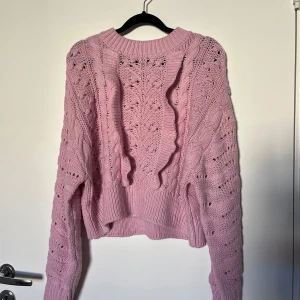 Stickad tröja - Ljusrosa stickad tröja med volang på framsidan. Köpt på H&M förra året men har bara legat i garderoben sedan dess. Nysick, använd 1 gång