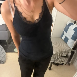 Svart linne med spets från Saint Tropez - Säljer ett snyggt svart linne från Saint Tropez i storlek M men passar XS, S. Den har fina spetsdetaljer och är perfekt för både vardag och fest. Den är i bra skick och väldigt bekvämt att ha på sig. 