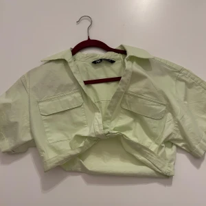 Zara kort skjorta - Zara kort skjorta/topp i ljusgrön/neon färg. Fint skick, köpt för fullt pris.