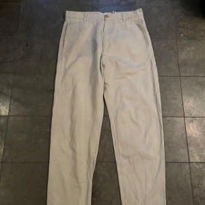 Beige byxor från COS - Säljer ett par stilrena beige byxor från COS. De har en klassisk design med en normal passform och är perfekta för både vardag och mer uppklädda tillfällen. Byxorna är tillverkade i ett bekvämt material och har en midwaist. Perfekta för höst och vår!