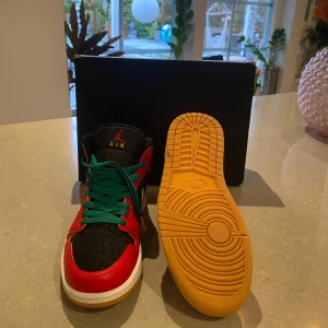 Nike Air Jordan 1 Mid  - Säljer nu ett par Air Jordan 1 Mid sneakers som aldrig har använts. Skorna har tillfälligt gröna skosnören som kan ersättas med svarta snören som   ingår. Har aldrig använts pga de varit för små. Nypris 3000. Hör av er vid frågor och funderingar!