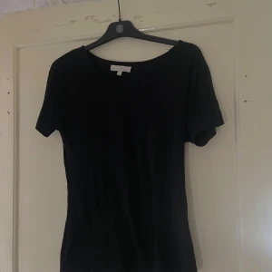 Svart topp från B.Young - Säljer en stilren svart topp från B.Young i storlek S. Toppen har en klassisk design med korta ärmar och rund halsringning. Perfekt för både vardag och fest!