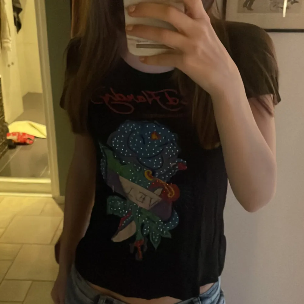 Jättecool baby tee från ed hardy. Bra skick, ingen rhinestone har ramlat av vad jag kan se. Skulle säga storlek xs men är väldigt stretchig så kan passa större också. Skriv om du har frågor, använd gärna köp nu🩷. T-paidat.