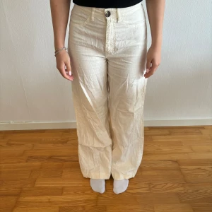 Beige byxor från Zara - Säljer ett par snygga beige byxor från Zara. De är högmidjade och har en loose passform som ger en avslappnad stil. Perfekta för både vardag och fest! Byxorna är i nyskick och gjorda av ett bekvämt material.