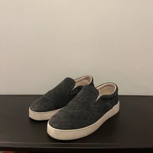 Bottega veneta  - Mörkblåa slip-ons ifrån märket bottega veneta, dessa skor säljs ej längre och är svårare att få tag på, detta är dels den populäraste färgen. Storlek 40-41, mycket bra skick förutom lite smutsiga på sulan.         Säkra dessa till vår/sommaren!! Skriv vid frågor!