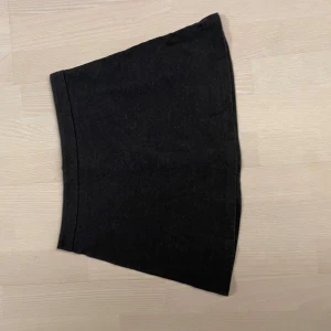 Grå kjol från Forever 21 - Snygg mörkgrå kortkjol från Forever 21 med dragkedja framtill. Perfekt för en stilren look. Tillverkad i ett mjukt material som ger en bekväm passform. 