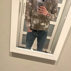 Woolrich windbreaker - Säljer en camo mönstrad jacka från Woolrich i grönt och vitt. Jackan har en dragkedja framtill och en huva. Perfekt för en avslappnad stil. Nypris ligger runt 2000kr tags finns kvar! Bara höra av sig vid eventuella frågor!