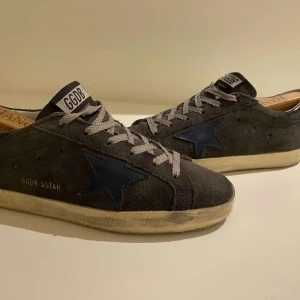 Golden goose skor - Säljer nu mina sälltsynta ggdb skor, som är i en grå mocka med blå stjärna. Skick 8-10 (lite slitage på sulan).  Nypris runt 5500 kr, mitt pris 1999. Säljer dem eftersom de blivit för små. Strl: 40, men passar 41-41,5. Vid minsta fundering är det bara att skriva.