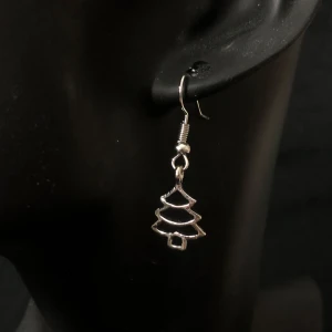 Silverfärgade örhängen med julgransmotiv - ❗️Tar endast emot Swish, skriv t mig vid köp ❗️Charmiga silverfärgade örhängen i form av julgranar. Perfekta för att ge en festlig touch till din outfit under julen. Lätta och bekväma att bära.