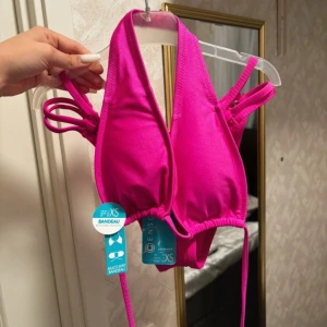 Rosa bikini från Censo - Snygg rosa bikini från Censo i bandeau-stil. Toppen har knytband och ribbad textur, vilket ger en trendig look. Perfekt för sommarens stranddagar!