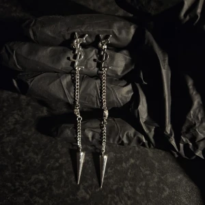 Ysl örhängen  - Snygga ysl örhängen med en kedja som hänger ner och avslutas med en spetsig detalj. Örhängena har en kristallinfattning och är silverpläterade.