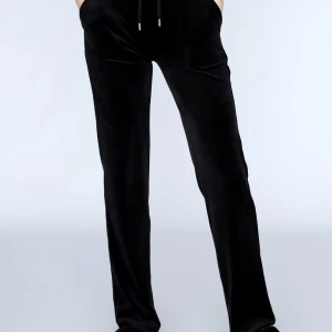 Svarta byxor från Juicy Couture - Snygga svarta byxor från Juicy Couture i mjukt material. De har en bekväm passform med dragsko i midjan och fickor både fram och bak. Perfekta för en avslappnad stil.