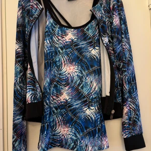 Mönstrad träningslinne och kofta. Storlek 158/164 - Säljer ett färgglatt träningslinne med ett abstrakt mönster i blått, rosa och vitt. Linnet har smala, korsade band i ryggen och är perfekt för träning. Materialet är lätt och andas bra. En för 50 kr, båda för 50 kr. 