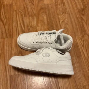 Vita sneakers med snörning - Snygga vita sneakers med klassisk design och snörning. Perfekta för en stilren look. De har en låg profil och är tillverkade i syntetmaterial.