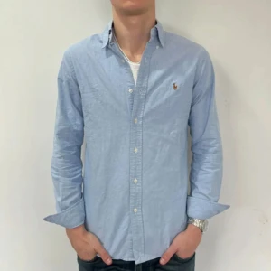 Blå skjorta från Ralph Lauren - Snygg ljusblå skjorta från Ralph Lauren. Knappt använd, säljer för den blivit för liten. Storlek S och skulle rekommendera om man är runt 170 cm lång. Pris ej hugget i sten!
