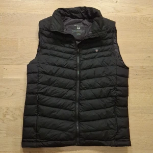 Svart dunväst från Gant - Snygg svart dunväst från Gant. Den är i jättebra skick och är i storlek XS. Om du har andra frågor är det bara att skicka ett meddelande ✅️