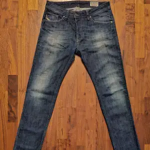 Snygga blå jeans från Diesel, modell Darron. De har en slim-tapered passform och klassisk femficksdesign. Perfekta för en stilren look.