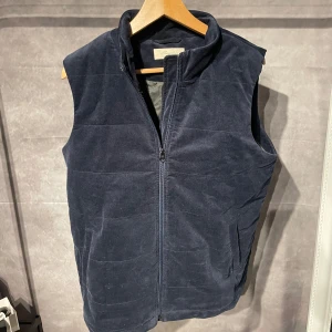 Seyless manchester väst  - Snygg och bekväm mörkblå manchesterväst med dragkedja framtill. Perfekt för lager-på-lager under kyliga dagar. Västen har en stilren design. 
