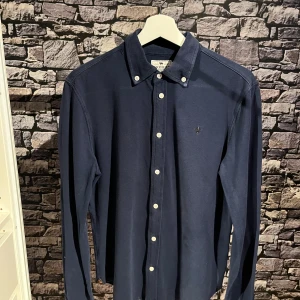 Mörkblå skjorta från Morris - Snygg mörkblå skjorta från Morris med klassisk krage och knappar framtill. Perfekt för en stilren look. Skriv vid frågor och funderingar