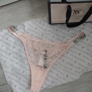 Rosa spetsunderkläder från Victoria's Secret - Säljer ett par rosa spetstrosor från Victoria's Secret. De har glittriga band med märkesloggan och en vacker spetsdesign. Perfekt för att känna sig extra lyxig. Helt nya med lappar kvar, storlek L men väldigt små i storleken så passar S/M