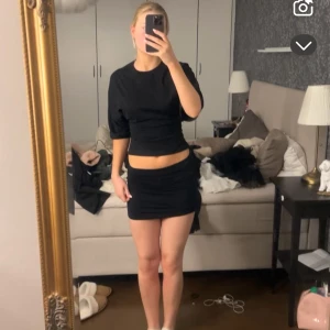 Svart t-shirt med knyt - Snygg svart t-shirt med knyt i ryggen. Tröjan har korta ärmar och en stilren design som passar perfekt till både jeans och kjol. 