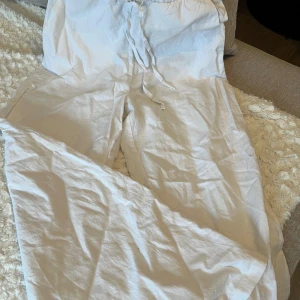 Vita linnebyxor från Vero Moda - Säljer ett par vita linnebyxor från Vero Moda. Byxorna har en avslappnad passform med dragsko i midjan för justerbar komfort. Perfekta för varma dagar med sitt lätta och luftiga material.