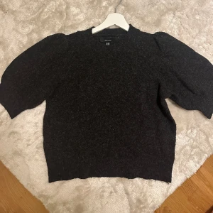 Mörkgrå tröja från Vero Moda - Säljer en stilren mörkgrå tröja från Vero Moda. Tröjan har puffiga trekvartsärmar och en rund halsringning. Perfekt för en avslappnad och trendig look. Passar bra till både jeans och kjol.