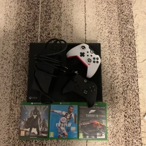 Xbox One med två handkontroller och spel - Säljer ett Xbox One med två handkontroller, en vit och en svart. Inkluderar tre spel: Destiny, FIFA 19 och Forza Motorsport 5. Perfekt för spelkvällar med vänner!🎮 Båda kontrollerna är trasiga men lätt att fixa hemma!