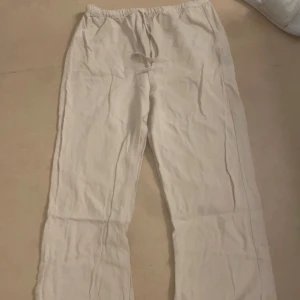Beige linnebyxor med snörning (petite) - Säljer ett par bekväma beige linnebyxor med snörning i midjan. Perfekta för en avslappnad stil och sköna att bära hemma eller på språng.
