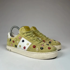 Valentino Flycrews - Snygga Valentino sneakers i ljusgrön mocka med färgglada blommor broderade över hela skon. De har en vit detalj på sidan och klassisk snörning. Skick: 4/5
