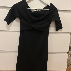 Svart klänning från Zara Trafaluc - Svart klänning från Zara Trafaluc. Klänningen har en offshoulder-stil och korta ärmar, perfekt för en chic look. Tillverkad i ett bekvämt material som ger en smickrande passform.