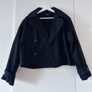 Svart jeansliknande jacka från Gina Tricot - Snygg svart jacka från Gina Tricot i. Den har en dubbelknäppt design med stora knappar och långa ärmar. Perfekt för en stilren look. Säljer denna jacka då den knappt kom till användning, skriv för ytterligare information! 😇